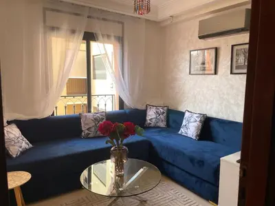 a blue couch in a living room with a glass table at Stylish & Comfy Gem 5 Star Location Balcony in Marrakech