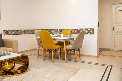 a dining room with a table and yellow chairs at Boho Haven Hivernage - Plein centre ville in Marrakech