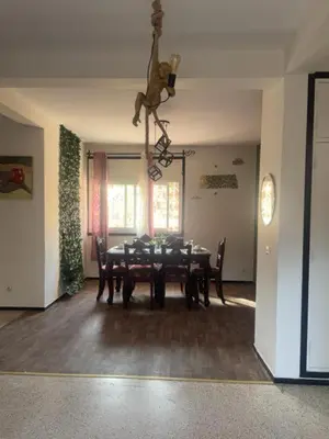a dining room with a table and a giraffe hanging from the ceiling at Your right choice in Marrakech