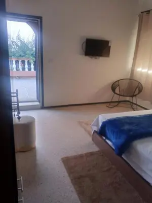 a bedroom with a bed and a tv on the wall at Your right choice in Marrakech
