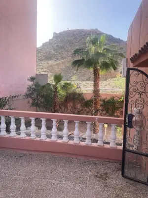 a balcony with a view of a palm tree and a mountain at Your right choice in Marrakech
