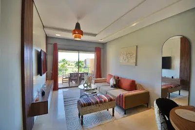 a living room with a couch and a table at Appartement Prestigia - Golf - Piscine - Restaurants in Marrakech