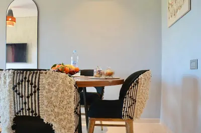 a dining room table with a bowl of fruit on it at Appartement Prestigia - Golf - Piscine - Restaurants in Marrakech