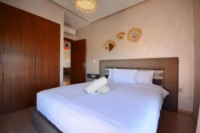a bedroom with a large white bed with white pillows at Appartement Prestigia - Golf - Piscine - Restaurants in Marrakech