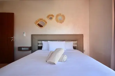 a bed with a towel on it with two mirrors on the wall at Appartement Prestigia - Golf - Piscine - Restaurants in Marrakech