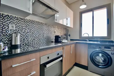 a kitchen with a washer and a washing machine at Appartement Prestigia - Golf - Piscine - Restaurants in Marrakech