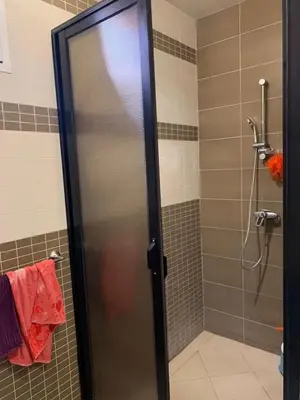 a shower with a glass door in a bathroom at beautiful apartment in Marrakech