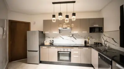 a kitchen with white cabinets and a refrigerator at Home Lucini To Marrakech in Marrakech