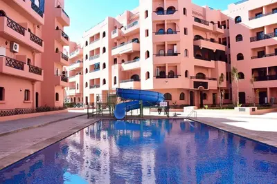a slide in a pool in front of a building at Home Lucini To Marrakech in Marrakech