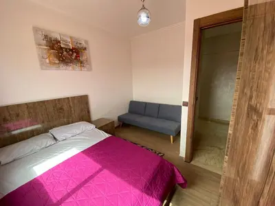 a bedroom with a pink bed and a blue couch at نور 5 كليز in Marrakech