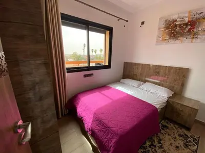 a bedroom with a pink bed and a window at نور 5 كليز in Marrakech