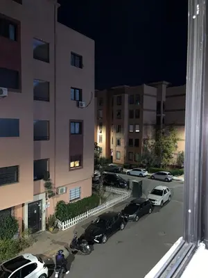 a group of cars parked in a parking lot next to a building at COZY Appartement in Marrakech