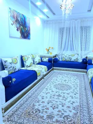 a living room with a blue couch and a rug at COZY Appartement in Marrakech