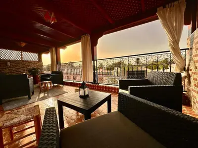 a living room with couches and a table and a large window at Triplex spacieux et familial avec une vue panoramique in Marrakech