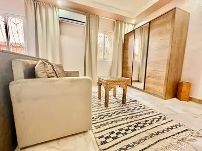 a living room with a couch and a table at Triplex spacieux et familial avec une vue panoramique in Marrakech