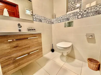 a white bathroom with a toilet and a sink at Triplex spacieux et familial avec une vue panoramique in Marrakech