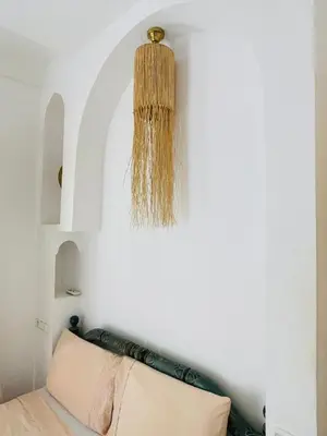 a chandelier hangs above a bed in a room at Diamant La Ville Rouge in Marrakech