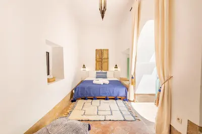 a bedroom with a bed in a white room at Peaceful Oasis Authentic Riad in Marrakech