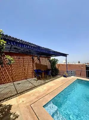 a swimming pool in front of a house with a fence at 2 Habitaciones en magnifico riad in Marrakech