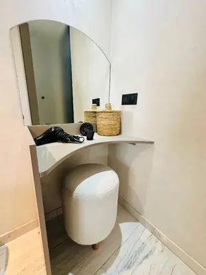 a bathroom with a vanity with a stool under a mirror at Sompteux Appartement 1 chambre Piscine à Marrakech in Marrakech