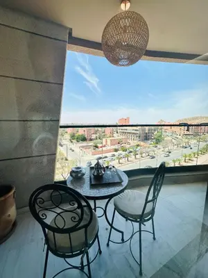 a room with a table and chairs and a large window at Sompteux Appartement 1 chambre Piscine à Marrakech in Marrakech