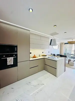 a kitchen with white cabinets and a stove top oven at Sompteux Appartement 1 chambre Piscine à Marrakech in Marrakech