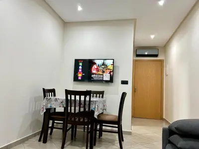 a dining room with a table and chairs and a tv at Immokesch1 in Marrakech