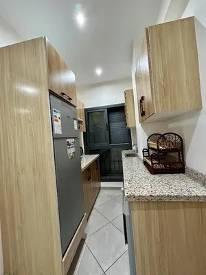 a kitchen with a stainless steel refrigerator and wooden cabinets at Immokesch1 in Marrakech