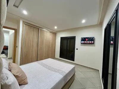 a bedroom with a bed and a tv on the wall at Immokesch1 in Marrakech