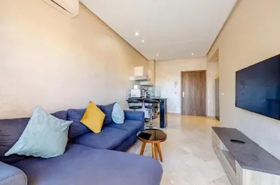 a living room with a blue couch and a tv at MARJANA Luxe appartement in Marrakech