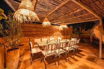 a dining room with a table and chairs and lights at Riad Banafsaj - Exclusif - 20mn de Jamaa Al Fnaa in Marrakech