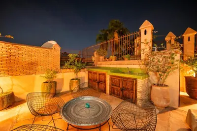 a patio with a table and chairs and a fence at Riad Banafsaj - Exclusif - 20mn de Jamaa Al Fnaa in Marrakech