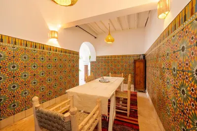 a dining room with a table and colorful wallpaper at Riad Banafsaj - Exclusif - 20mn de Jamaa Al Fnaa in Marrakech