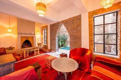 a living room with a couch and a table at Riad Banafsaj - Exclusif - 20mn de Jamaa Al Fnaa in Marrakech