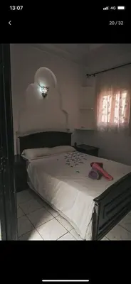 a bedroom with a bed with a red object on it at Tourist Riad in Marrakech