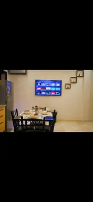 a dining room with a table and chairs and a tv at Love studio in Marrakech