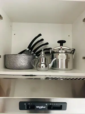 a shelf with pots and pans on top of an oven at Sublime Appartement 1 chambre WIFI à Marrakech in Marrakech