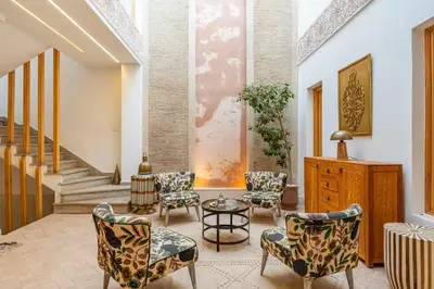 a living room with chairs and a table and stairs at Riad SWAN-exclusif - Piscine chauffée - Petit déjeuner in Marrakech