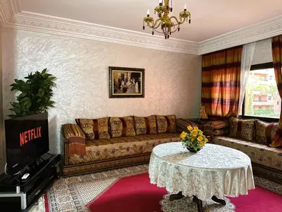 a living room with a couch and a table at Calme et cozy avec piscine in Marrakech