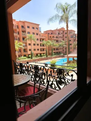 a balcony with a table and chairs and a pool at Calme et cozy avec piscine in Marrakech