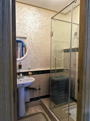 a bathroom with a sink and a glass shower at Calme et cozy avec piscine in Marrakech