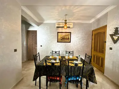 a dining room with a black table and chairs at Calme et cozy avec piscine in Marrakech
