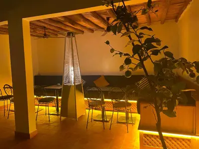a room with a table and chairs and a plant at Riad Madinina in Marrakech