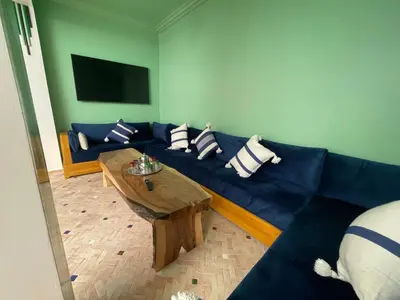 a living room with a blue couch and a table at Riad Madinina in Marrakech