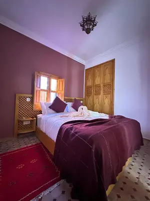 a bedroom with a large bed and a window at Riad Madinina in Marrakech
