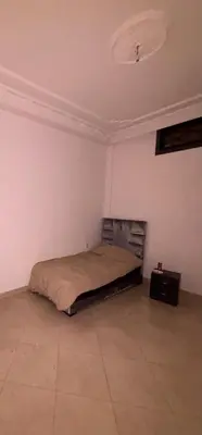 a bedroom with a bed in the corner of a room at Petite villa cosy et agréable avec jacuzzi privé in Marrakech