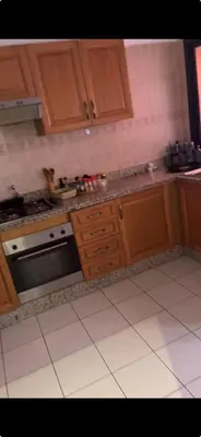 a kitchen with wooden cabinets and a stove at Petite villa cosy et agréable avec jacuzzi privé in Marrakech