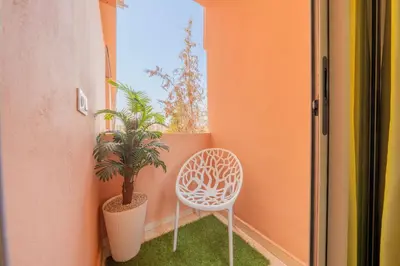 a white chair sitting in a room with a plant at L'Havre de paix de Guéliz au Coucher de Soleil in Marrakech