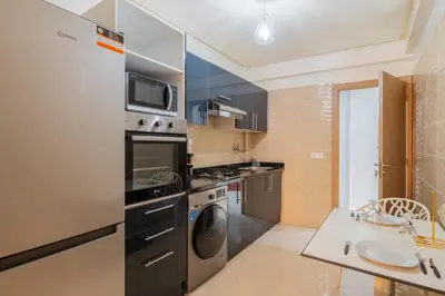 a kitchen with a refrigerator and a washer and dryer at L'Havre de paix de Guéliz au Coucher de Soleil in Marrakech
