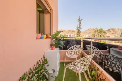 a balcony with chairs and a refrigerator on a balcony at L'Havre de paix de Guéliz au Coucher de Soleil in Marrakech